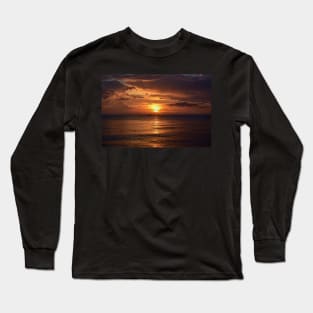 Mesmerizing vertical shot of the sun setting behind the clouds over the calm ocean Long Sleeve T-Shirt